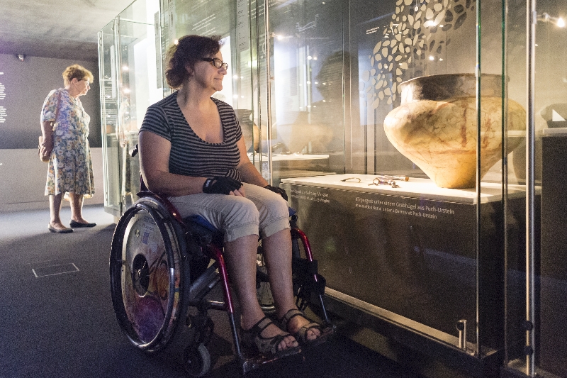 Rollstuhlfahrerin in der Ausstellung im Keltenmuseum